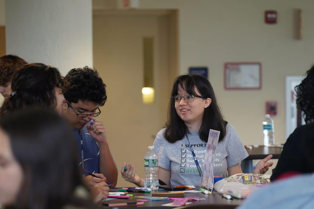 An intern working with students at a PALS table