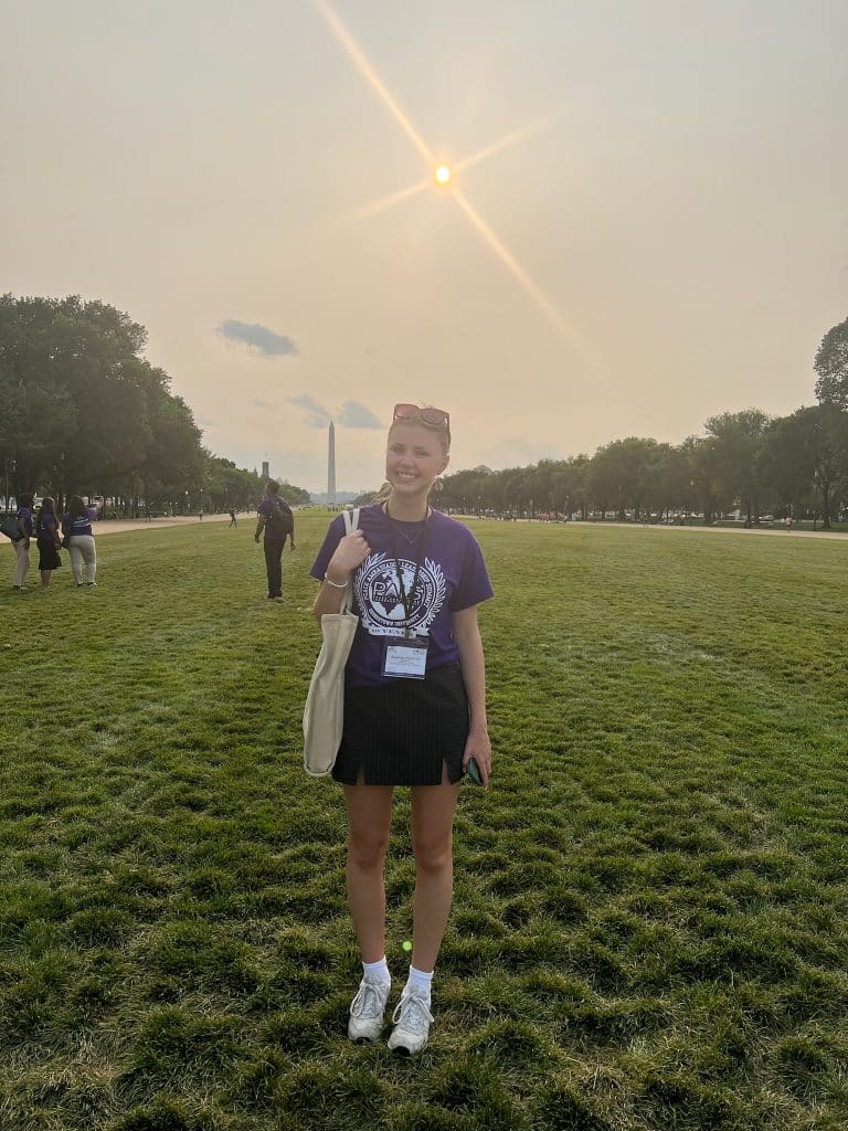 An NVEEE intern in a PALS shirt on a university campus