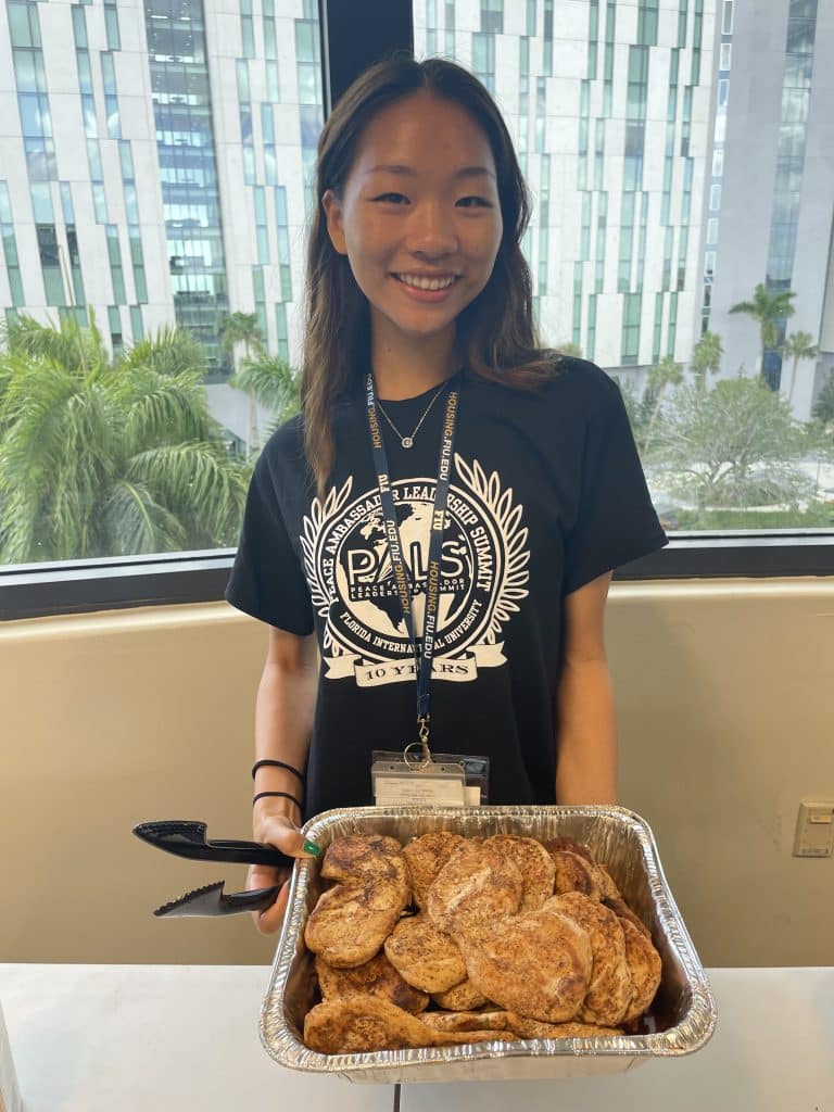 NVEEE intern in a PALS shirt serving food at a PALS event