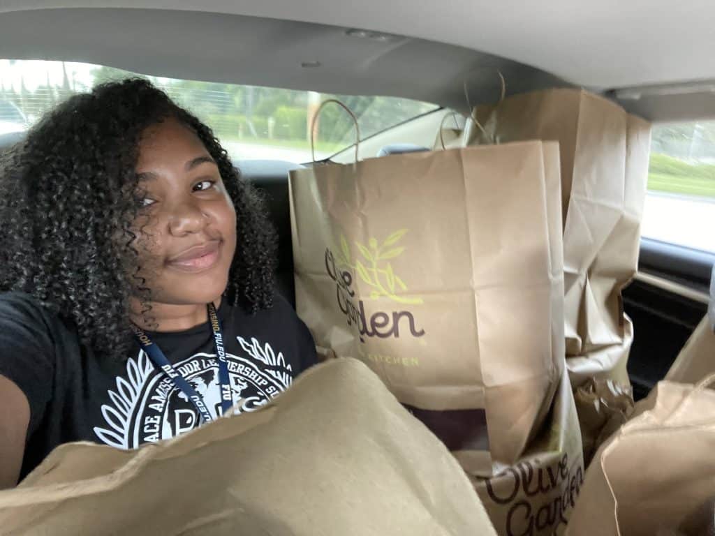 An NVEEE intern with bags of supplies for an NVEEE program