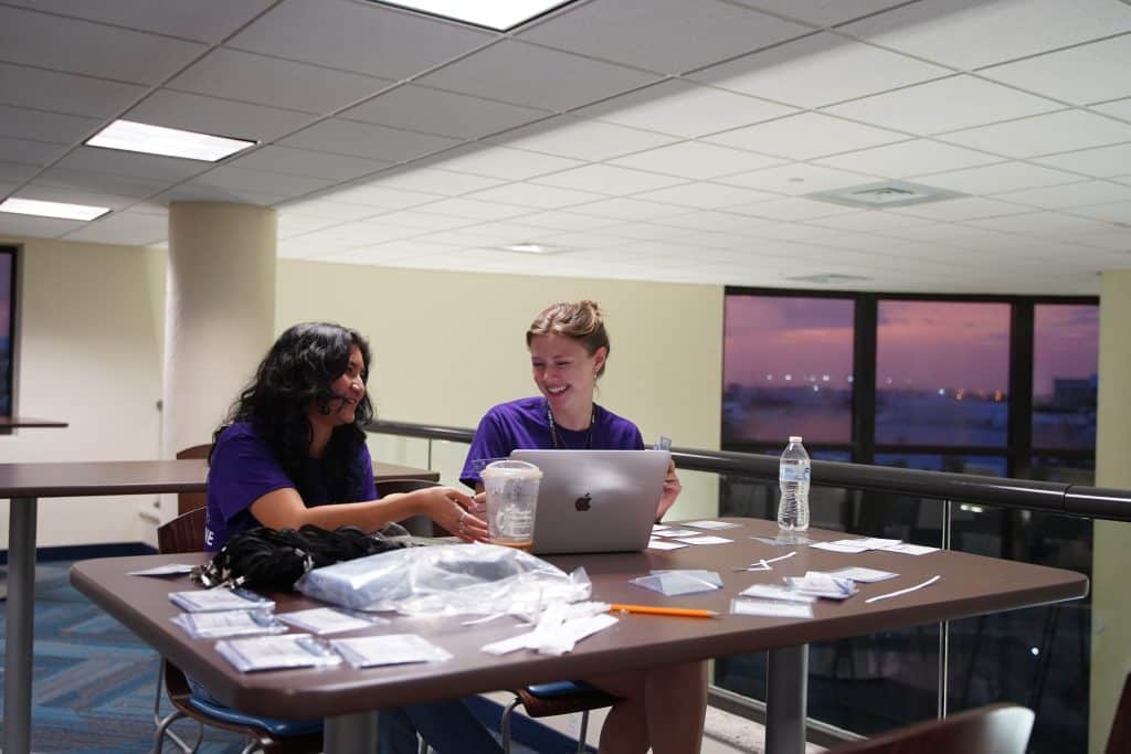 Two interns organizing participant materials