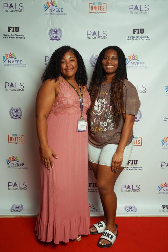 Two interns at the PALS banquet step-and-repeat