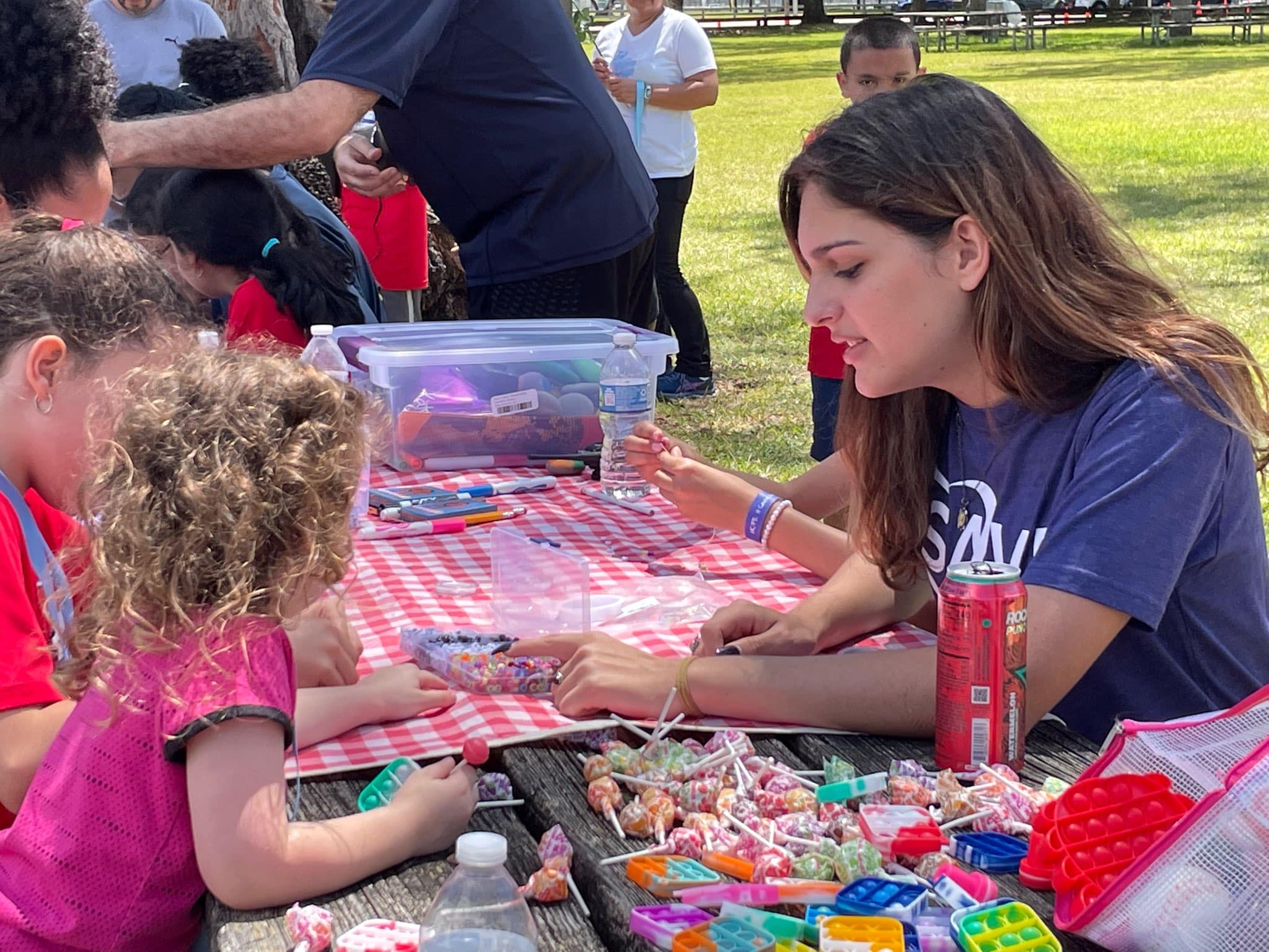 PALP student helping children with a craft project at a community event