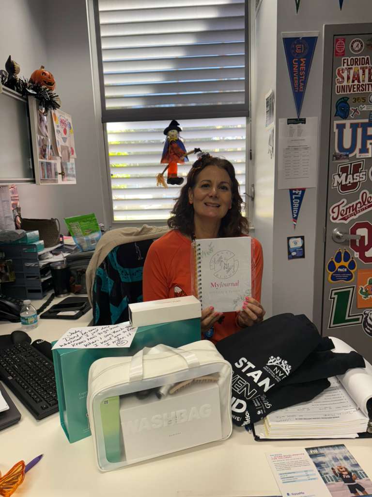 An educator at her desk with her Share the Care bags and journal