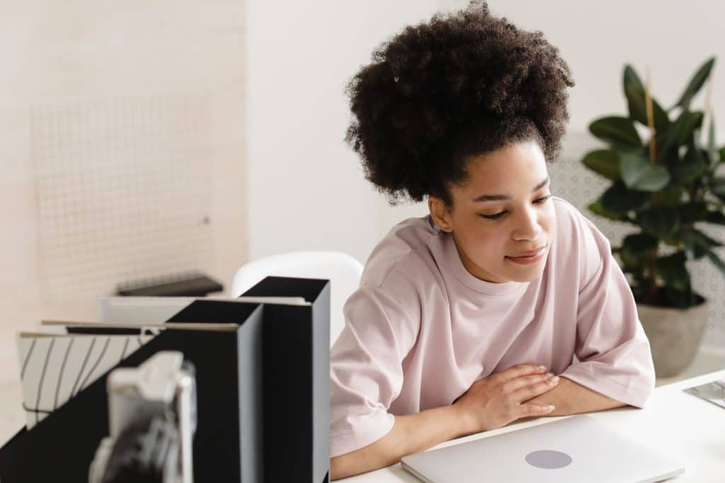 College student resting her arms on a closed laptop at the end of the day